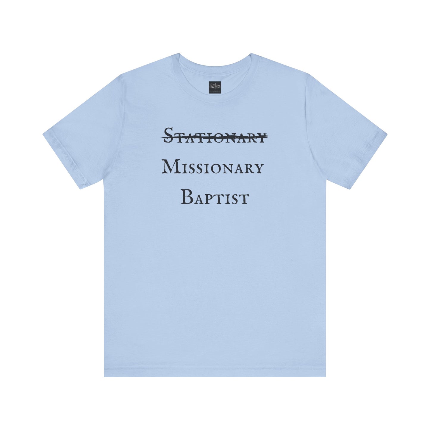 A baby blue t-shirt with the word Stationary marked out with the words Missionary Baptist in bold