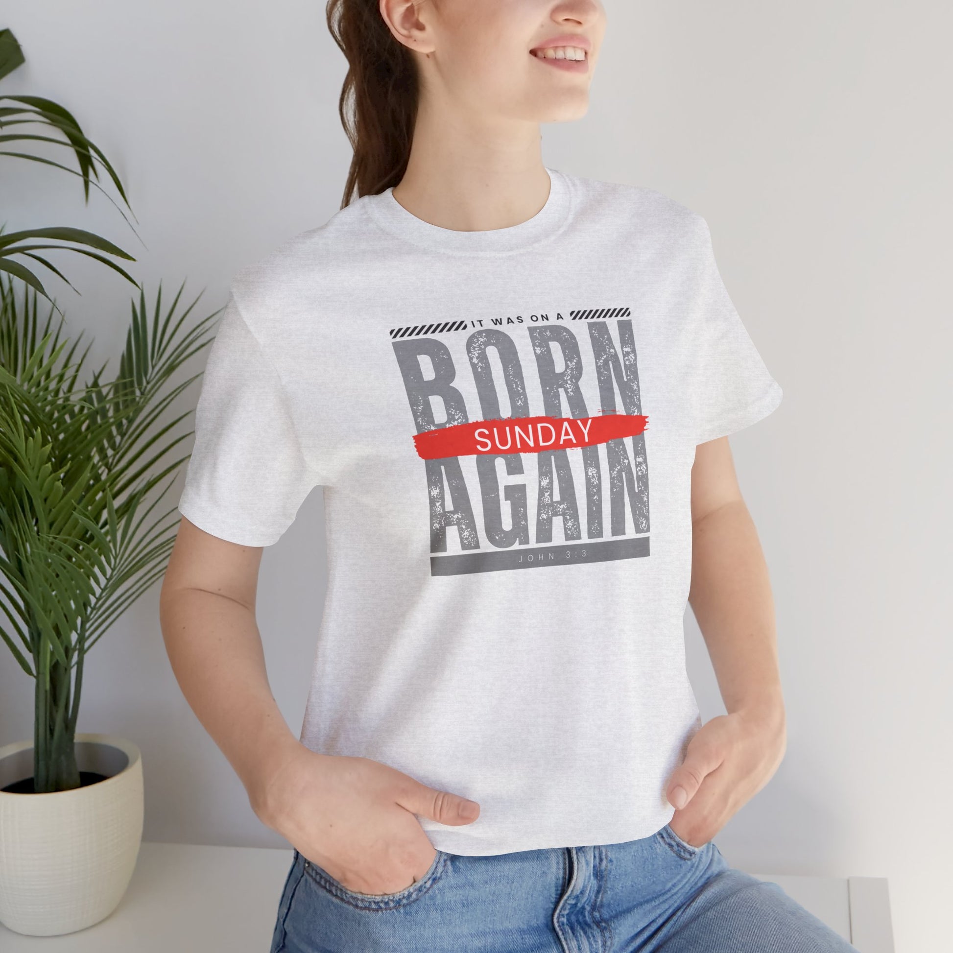 A female wearing a white t-shirt with the words Born Again it was on a Sunday with the scripture John 3:3