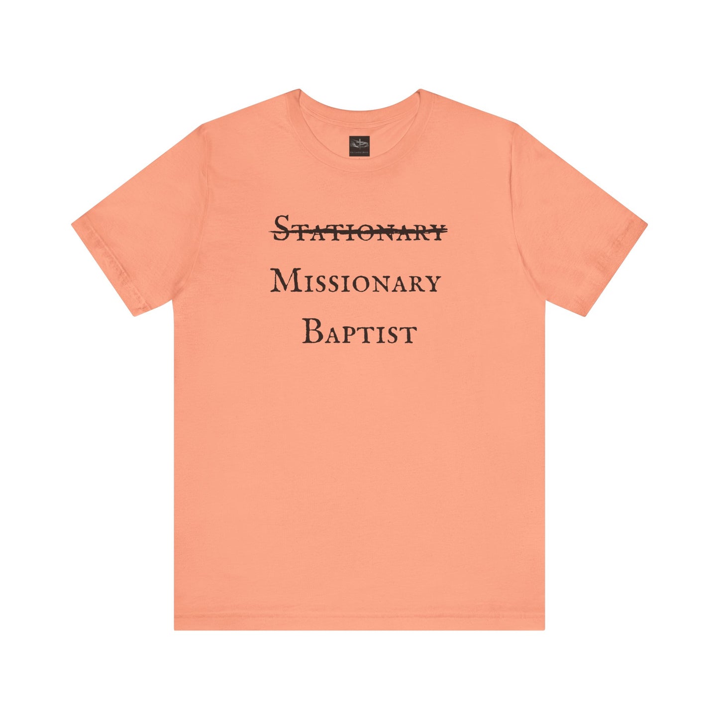 A sunset orange t-shirt with the word Stationary marked out with the words Missionary Baptist in bold