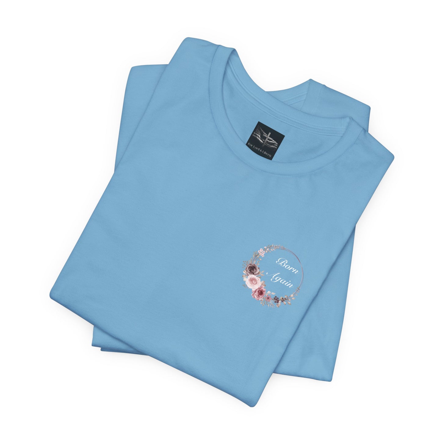 A ocean blue t-shirt with the words Born Again with a flower wreath on the front left pocket