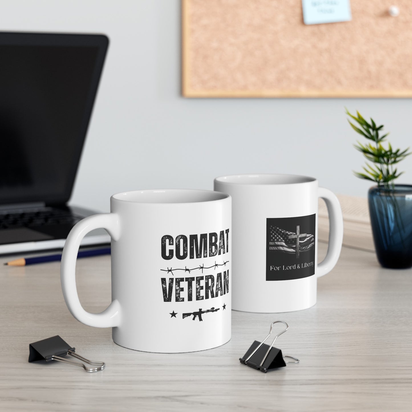 a white mug with the words Combat Veteran with an M-4 rifle and barb wire and another mug with the for lord and liberty logo that is sitting on a desk