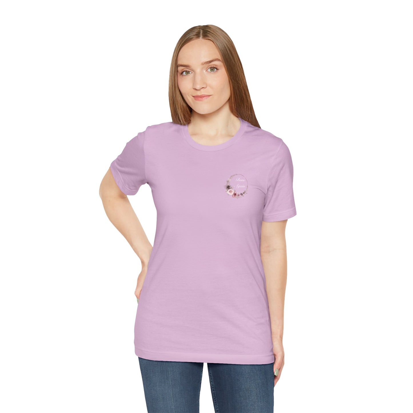 A female wearing a lilac t-shirt with the words Born Again with a flower wreath on the front left pocket