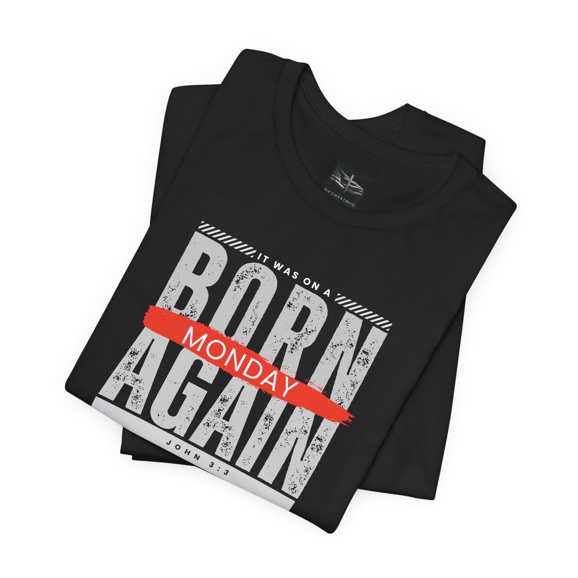 A black t-shirt with the words Born Again it was on a Monday with the scripture John 3:3