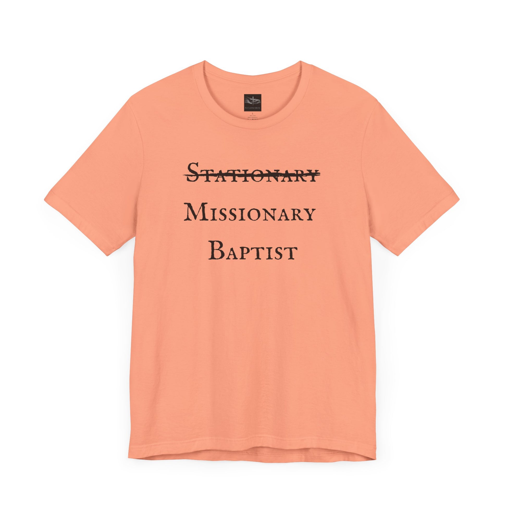 A sunset orange t-shirt with the word Stationary marked out with the words Missionary Baptist in bold