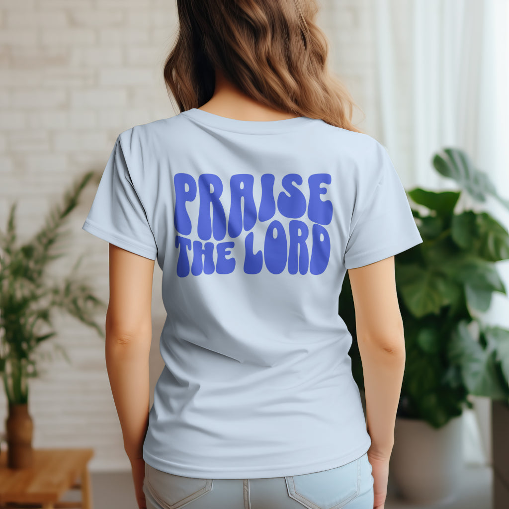 a woman wearing a light blue t-shirt with the words Praise The Lord in blue