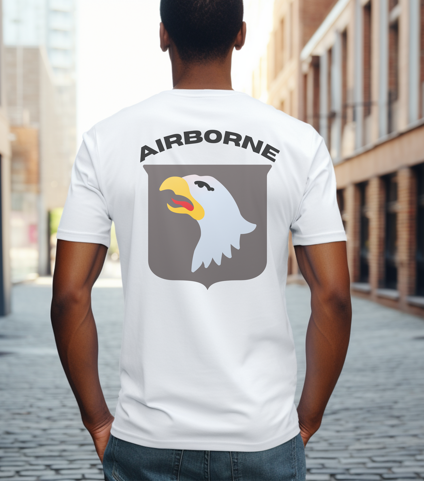 African American male wearing a white 101st Airborne t-shirt with a background of a city