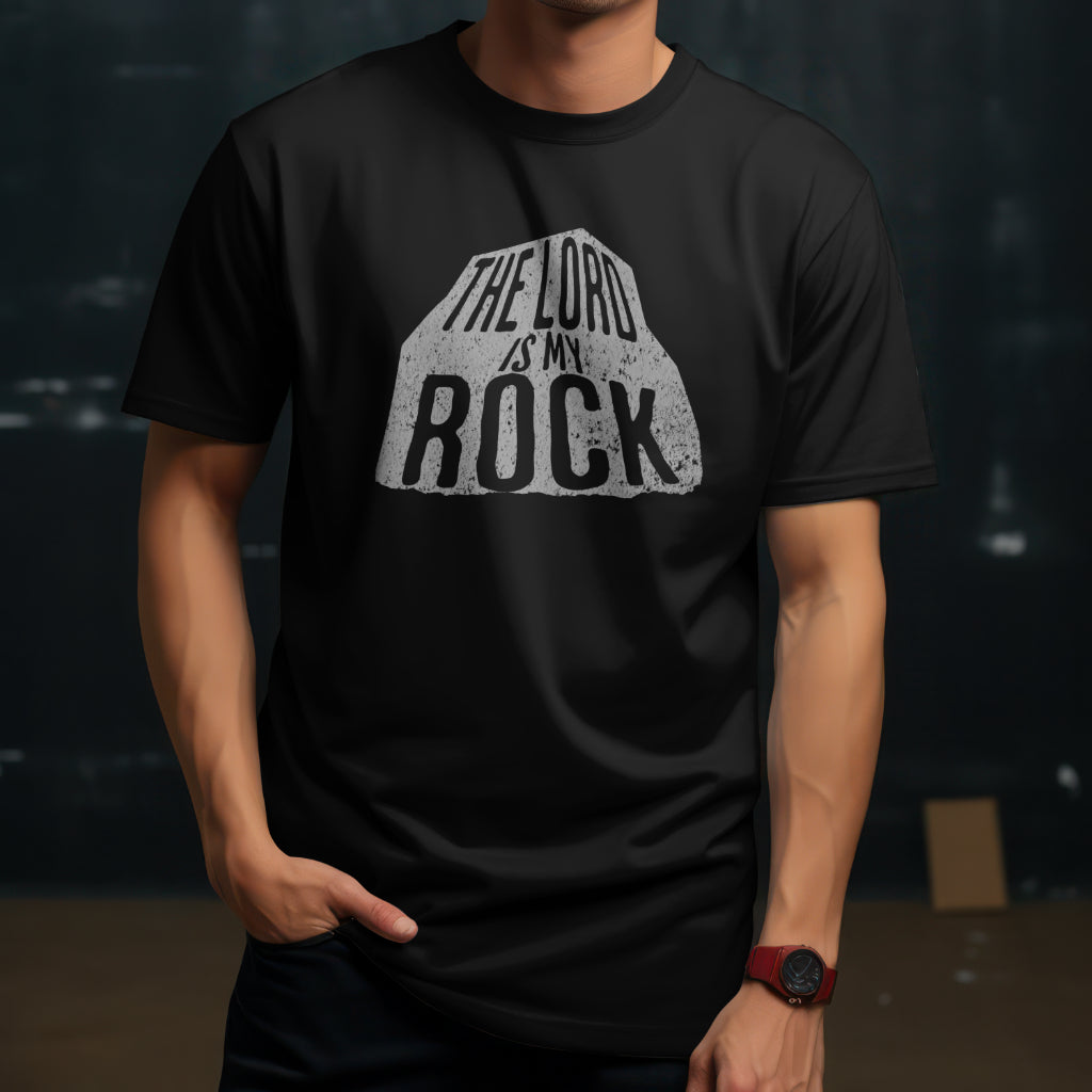 A man wearing a black t-shirt with a rock and inside says the Lord is my Rock