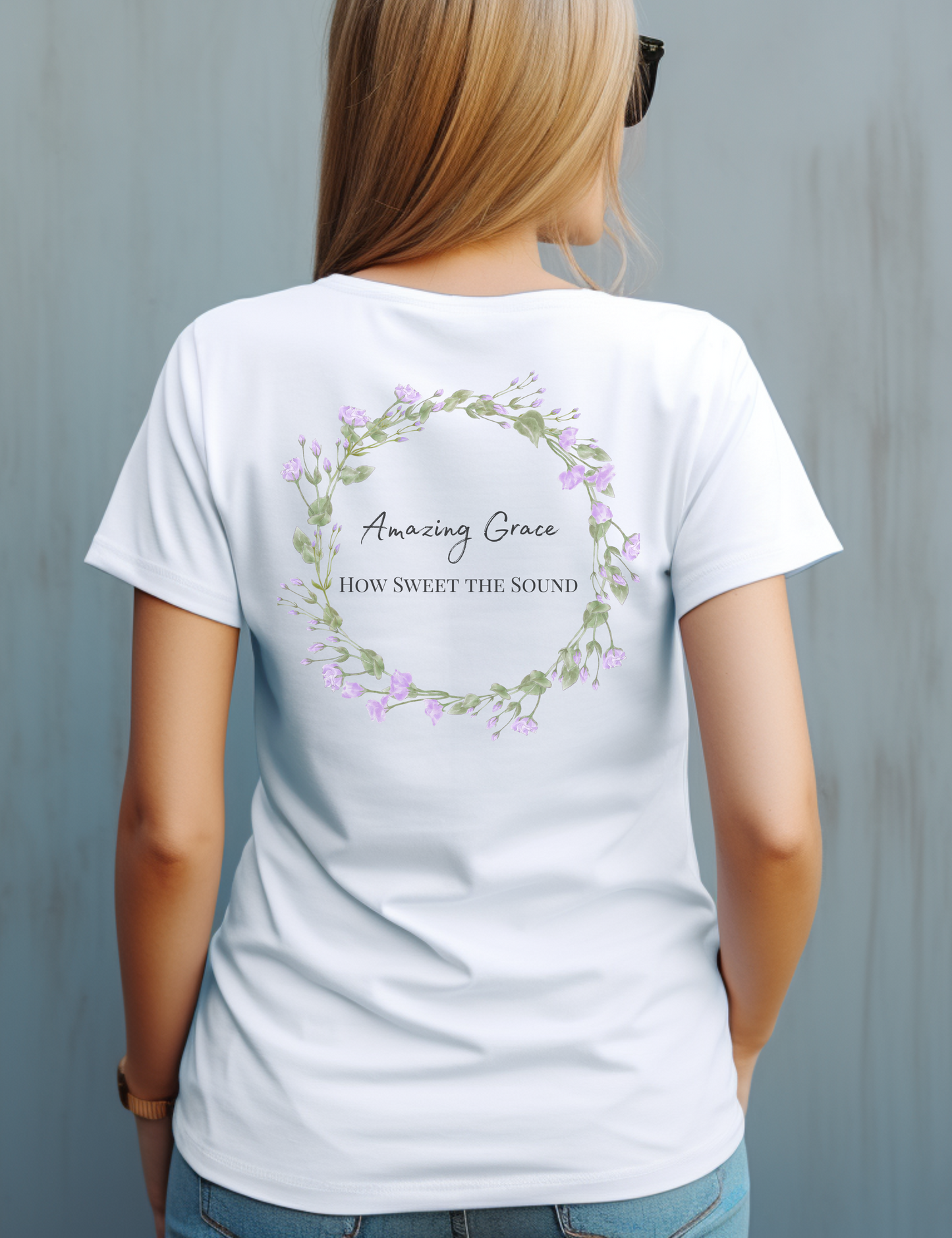 A white female wearing a white t-shirt with the words Amazing Grace how sweet the sound on the back on the t-shirt 